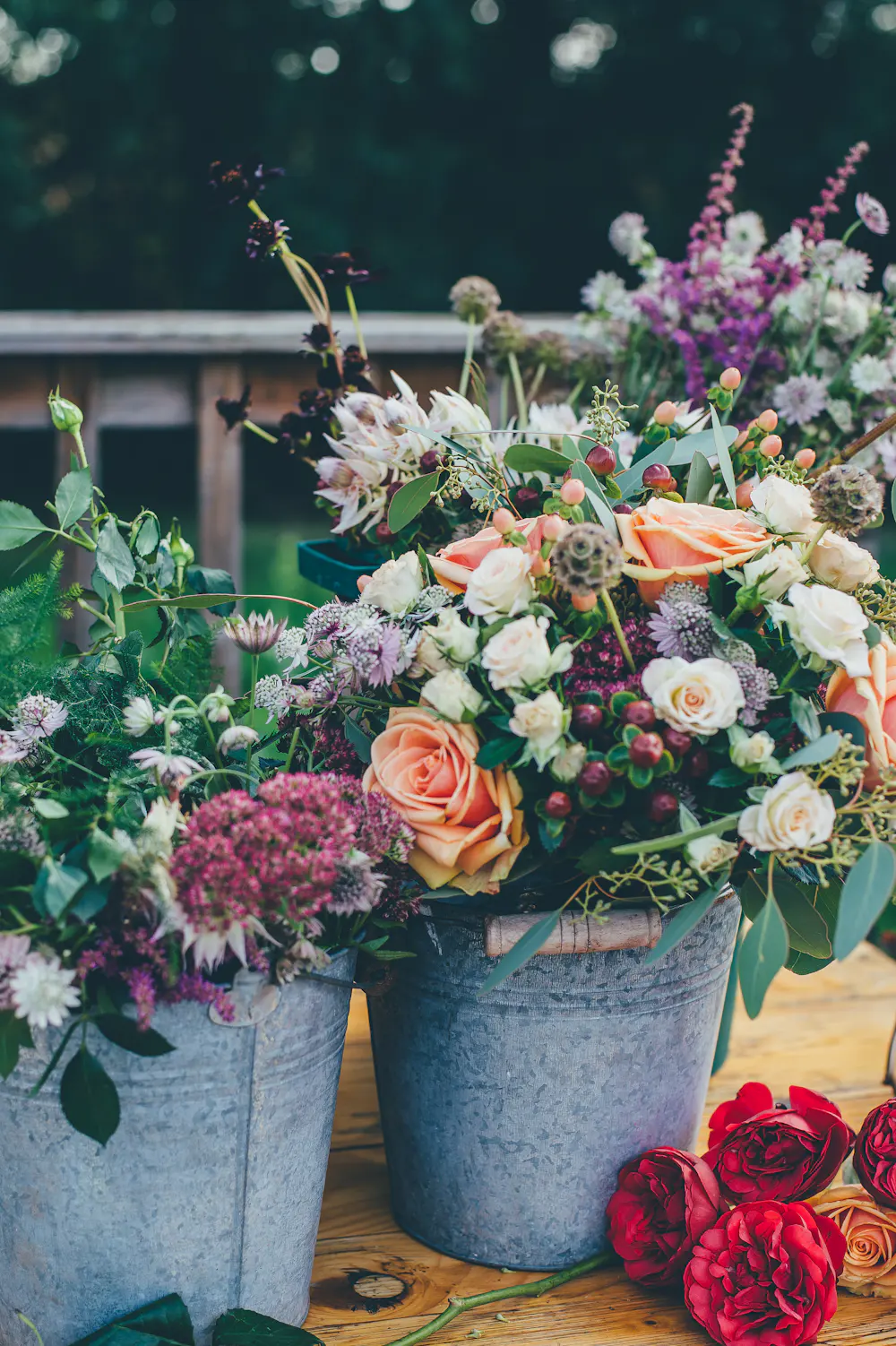 Two galvanised buckets full of roses, scabious, astrantia and foliage